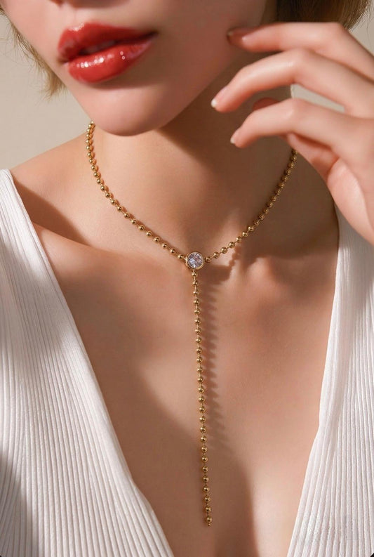 Elegant beaded lariat necklace with bezel-set stone and drop chain. Minimalist Y necklace available in gold or silver. Perfect for everyday wear or layering.