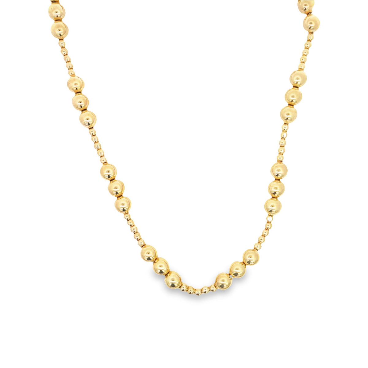 A gleaming gold bead necklace drapes gracefully against a clean white background.