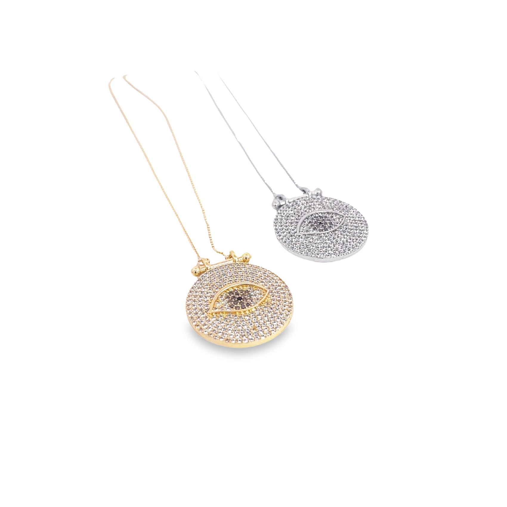 Two delicate evil eye pendant necklaces, one in gold and one in silver, sparkle against a white background.