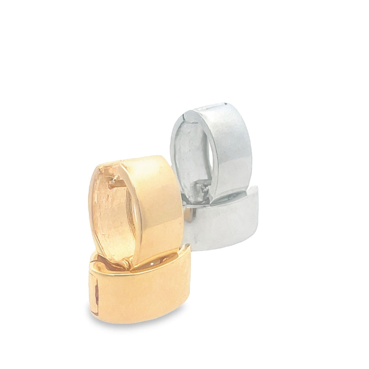 A pair of gold and silver huggie hoop earrings stand stacked against a clean white background.