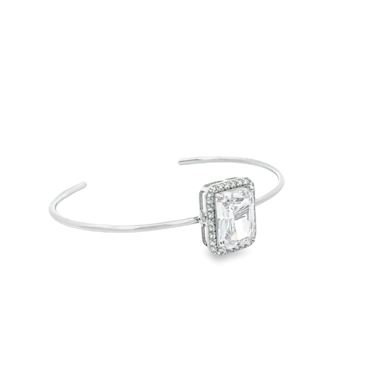 A sleek silver cuff bracelet features a stunning emerald-cut gemstone framed by a delicate halo of sparkling diamonds.