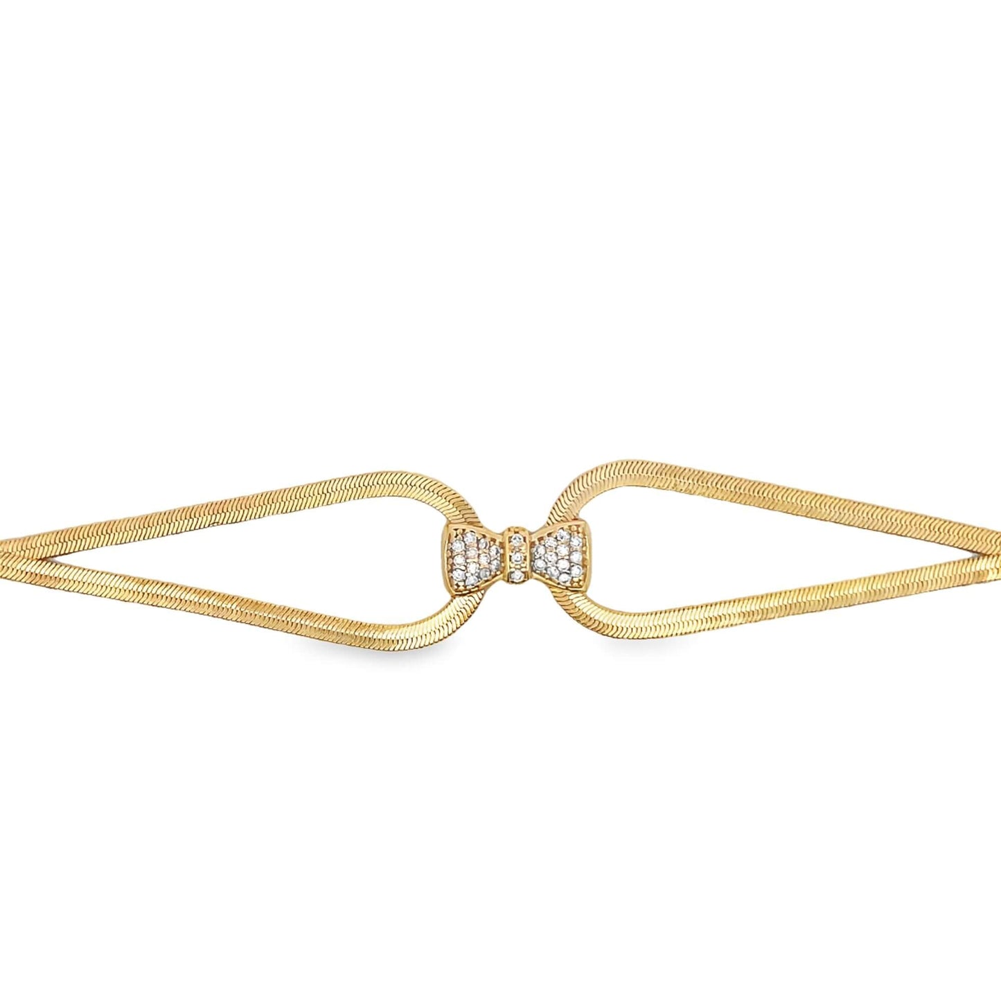 A gold herringbone chain bracelet features a sparkling diamond-encrusted bow clasp at the center.