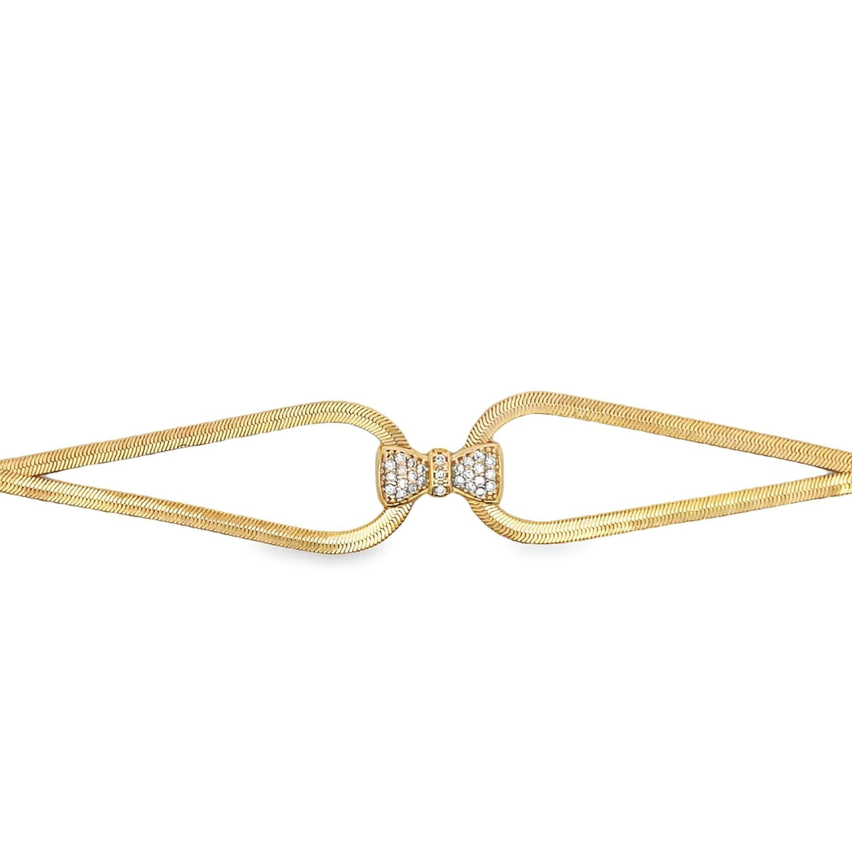 A gold herringbone chain bracelet features a sparkling diamond-encrusted bow clasp at the center.