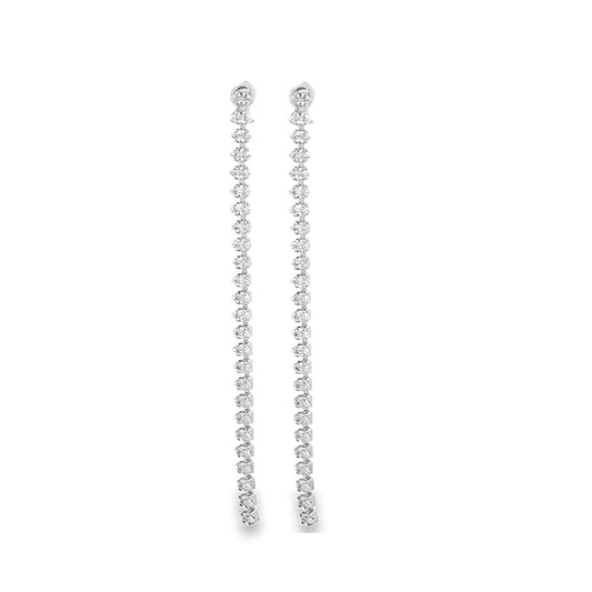 A pair of elegant long diamond drop earrings dangle vertically against a plain white background.