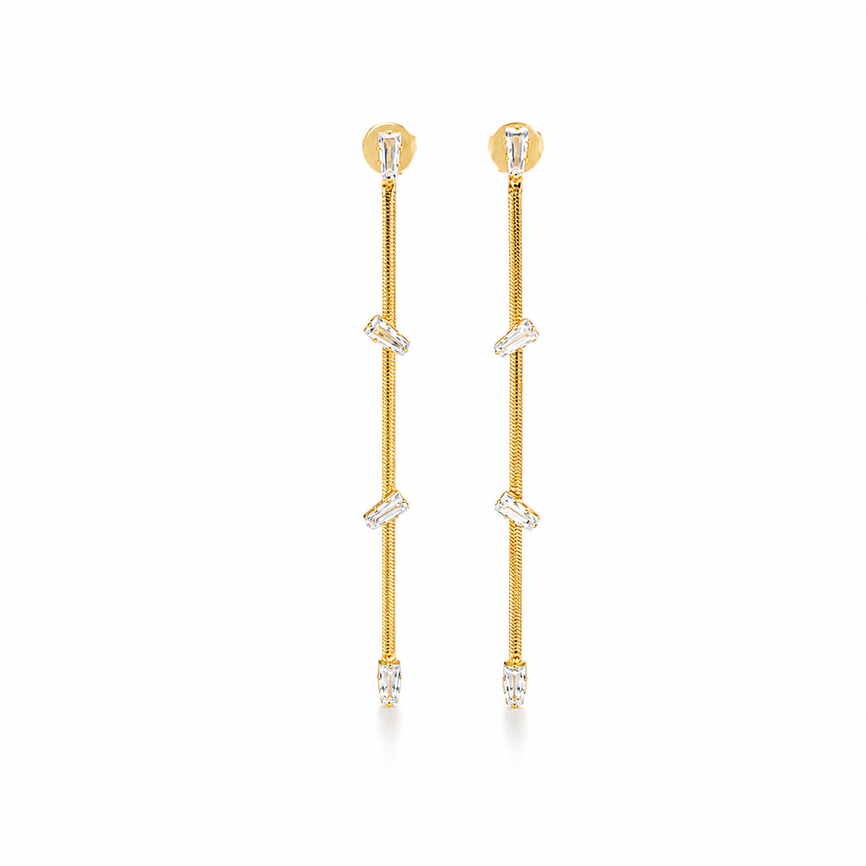A pair of elegant long gold drop earrings feature delicate chains studded with sparkling baguette-cut crystals against a clean white background.