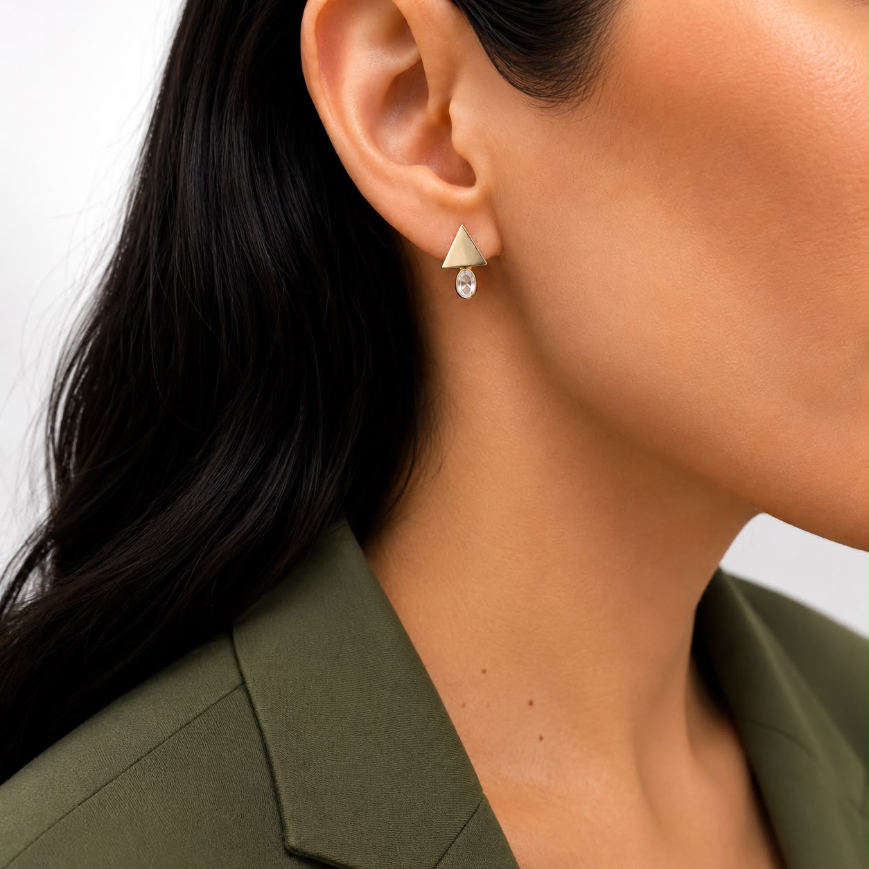 Shop geometric triangle stud earrings featuring sparkling oval CZ stones. Crafted in 18K Gold Filled and available in Gold and Rhodium finishes.