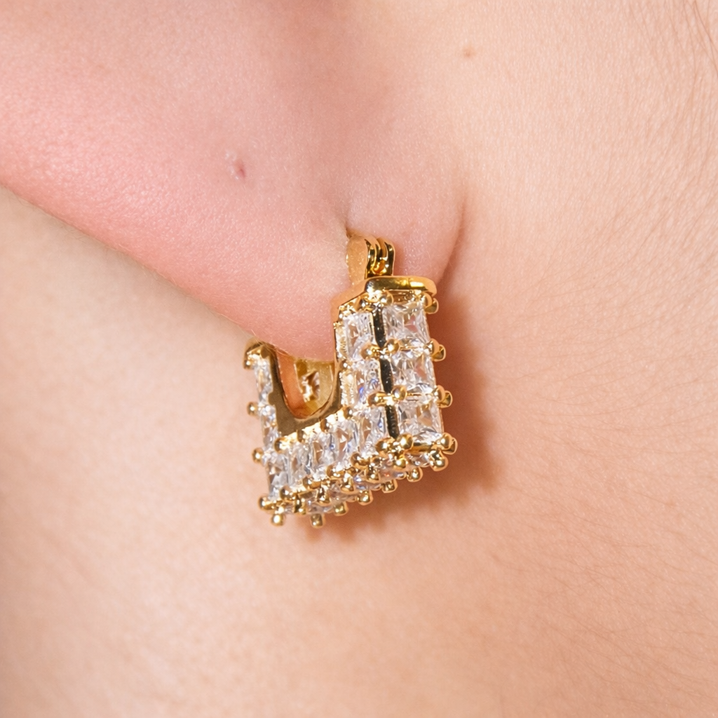 Modern square huggie hoop earrings with baguette-style CZ stones. Geometric U-shape design available in gold or silver. Perfect for stacking or everyday wear.