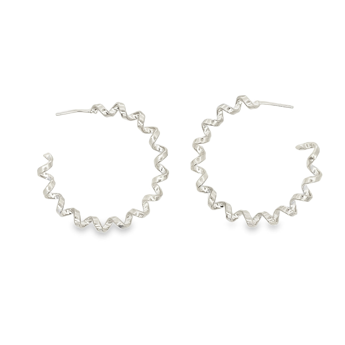 A pair of silver spiral hoop earrings rests against a clean white background.