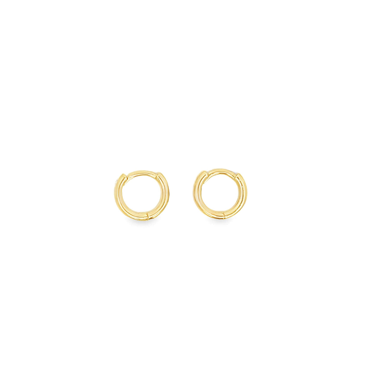 A pair of polished gold huggie hoop earrings rests against a clean white background.