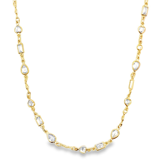 A delicate gold chain necklace sparkles with alternating diamond station stones in various geometric cuts against a clean white background.