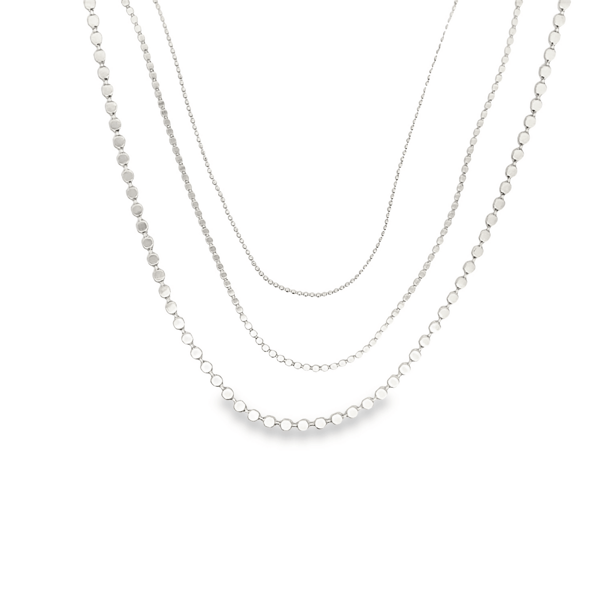 Three layered silver beaded necklaces hang gracefully against a plain white background.