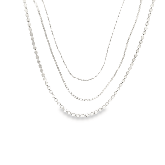 Three layered silver beaded necklaces hang gracefully against a plain white background.