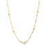 A delicate gold necklace features alternating small beads, cylindrical bars, and textured spheres against a white background.