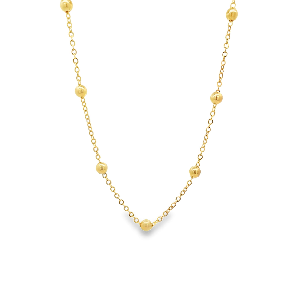 A delicate gold chain necklace sparkles against a clean white background, featuring evenly spaced golden bead stations along its length.