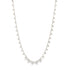 A delicate silver chain necklace features dangling bead charms.