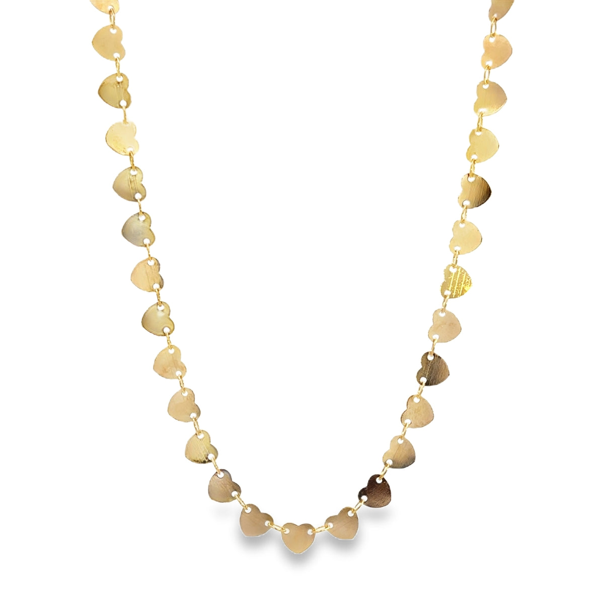 A delicate gold chain necklace drapes in a loop, featuring multiple shiny heart-shaped charms dangling along its length against a plain white background.