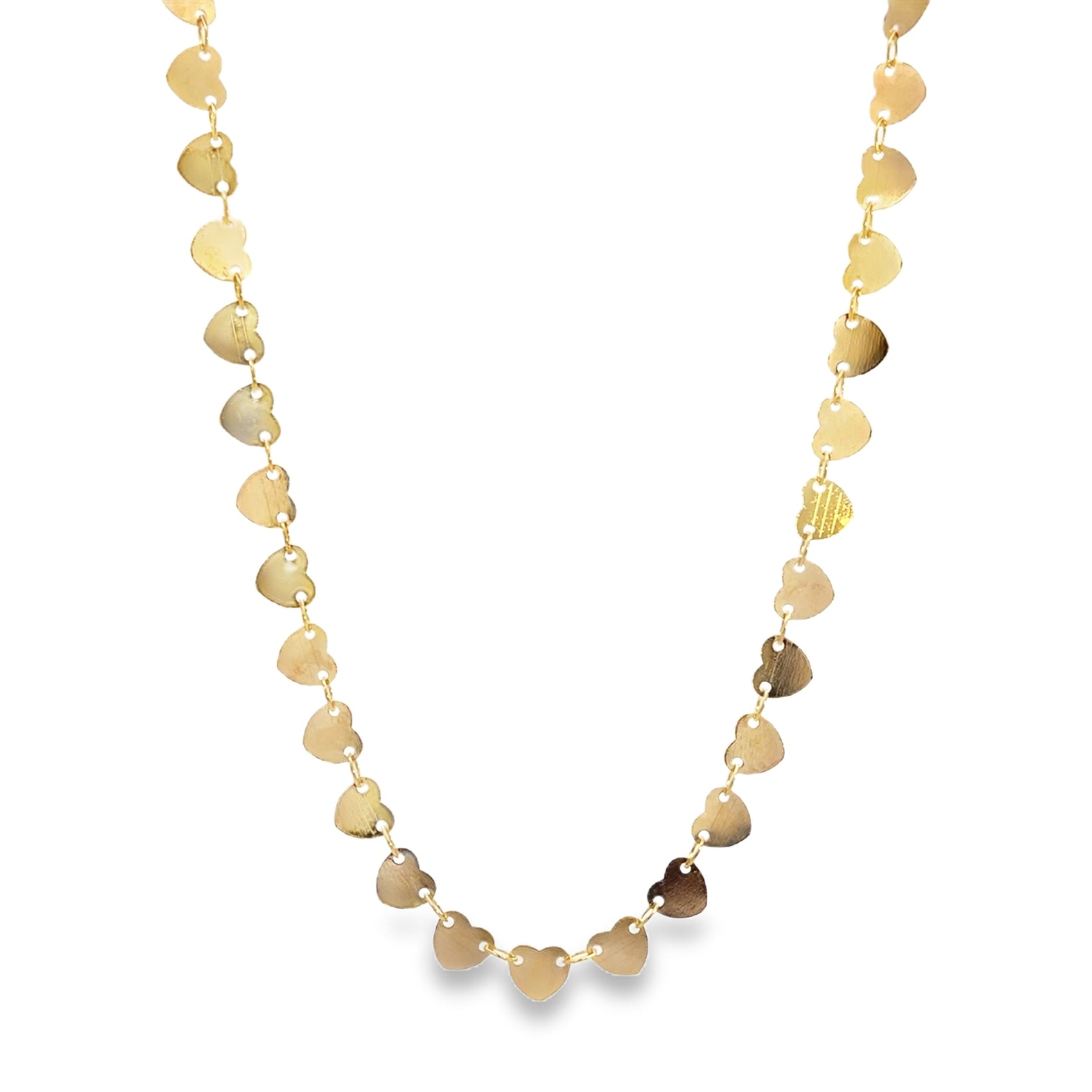 A delicate gold chain necklace drapes in a loop, featuring multiple shiny heart-shaped charms dangling along its length against a plain white background.
