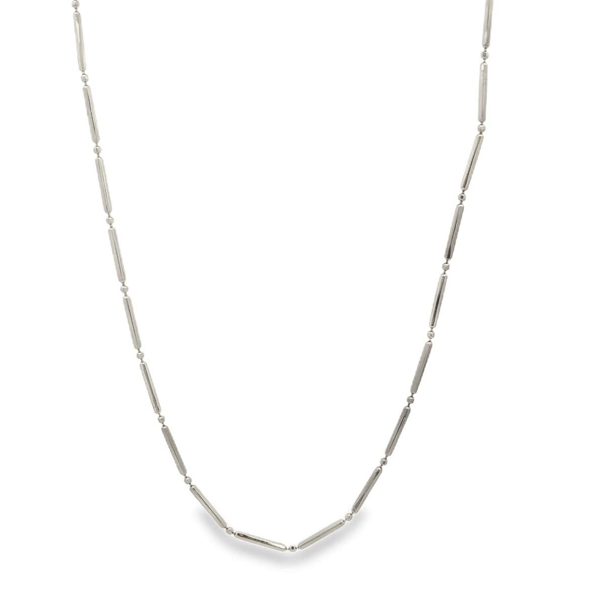 A delicate silver bar station necklace features evenly spaced metallic beads along a fine chain against a white background.