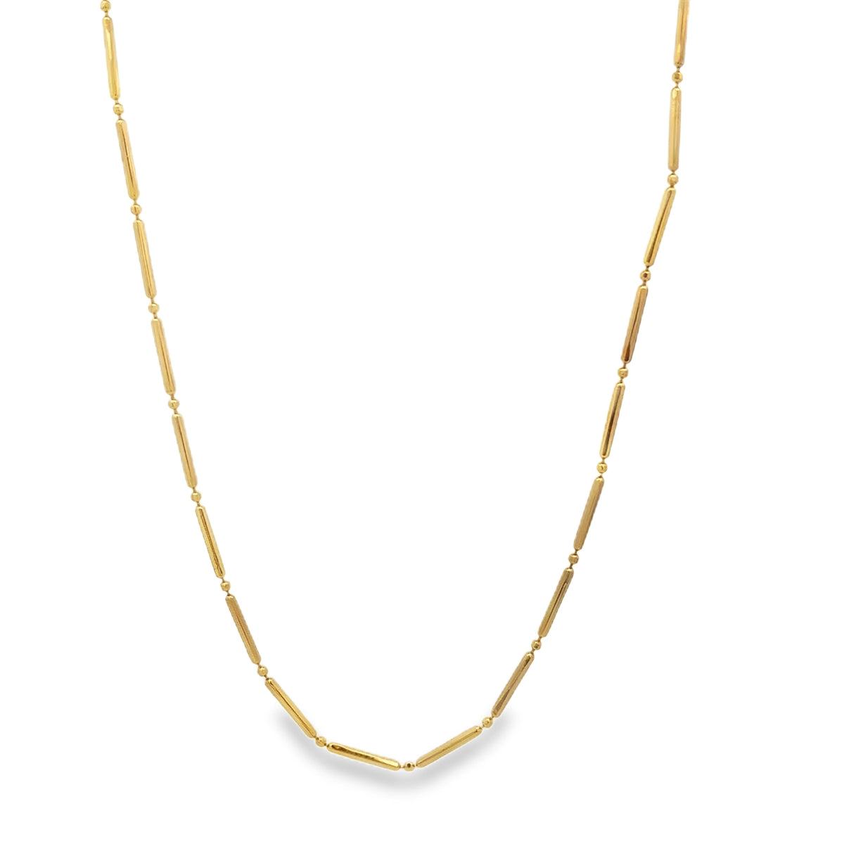 A delicate gold chain necklace features alternating elongated bar beads and small round spacer beads.