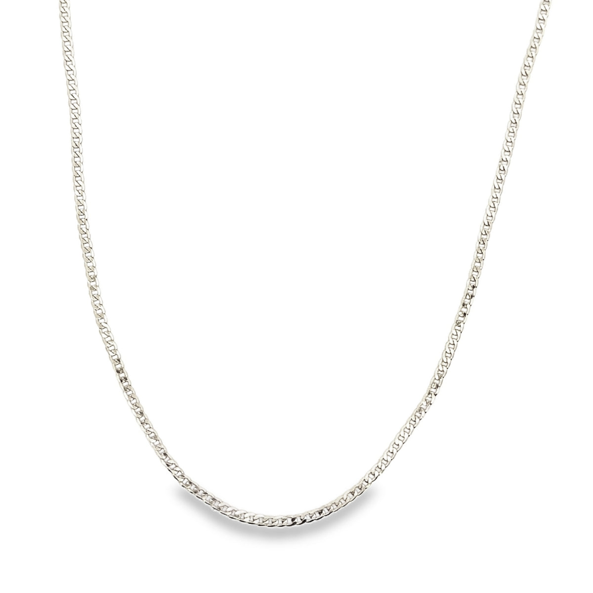 A delicate silver curb chain necklace rests in a graceful curve against a clean white background.