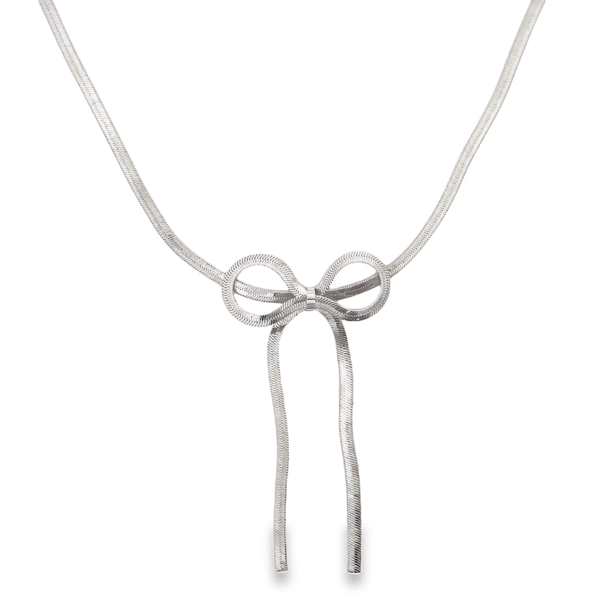A delicate silver herringbone chain necklace features a stylish bow pendant hanging against a plain white background.