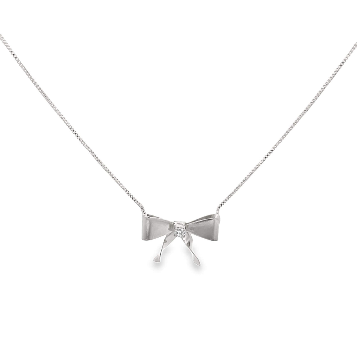 A delicate silver bow necklace features a sparkling diamond at its center against a clean white background.