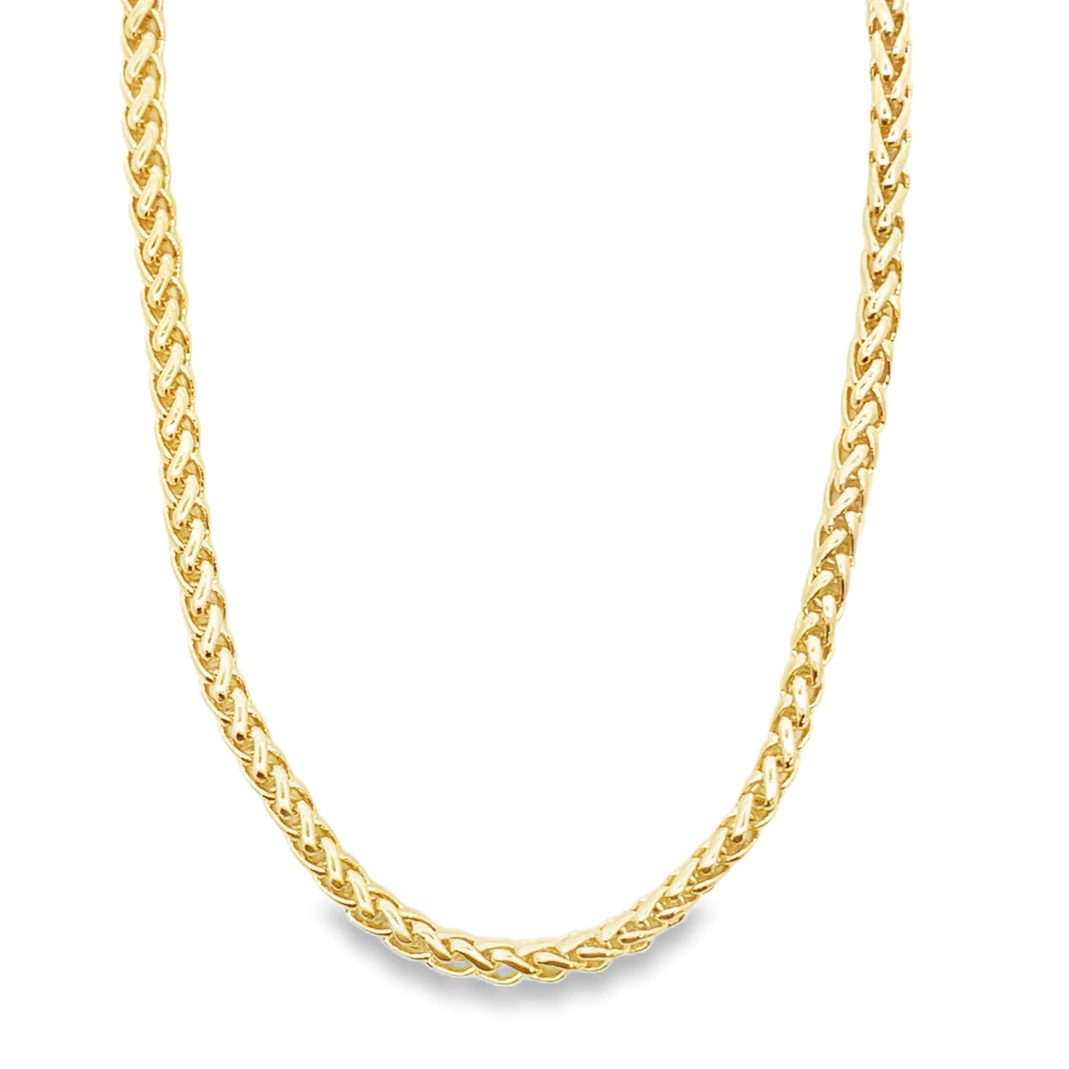 A polished gold wheat chain necklace gleams against a white background.