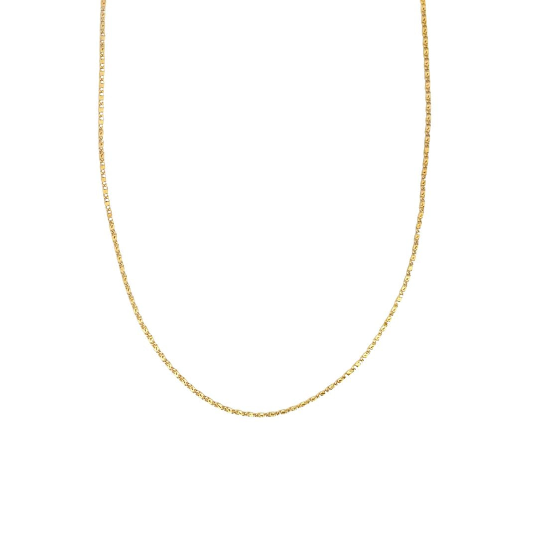 A delicate gold chain necklace hangs against a plain white background.