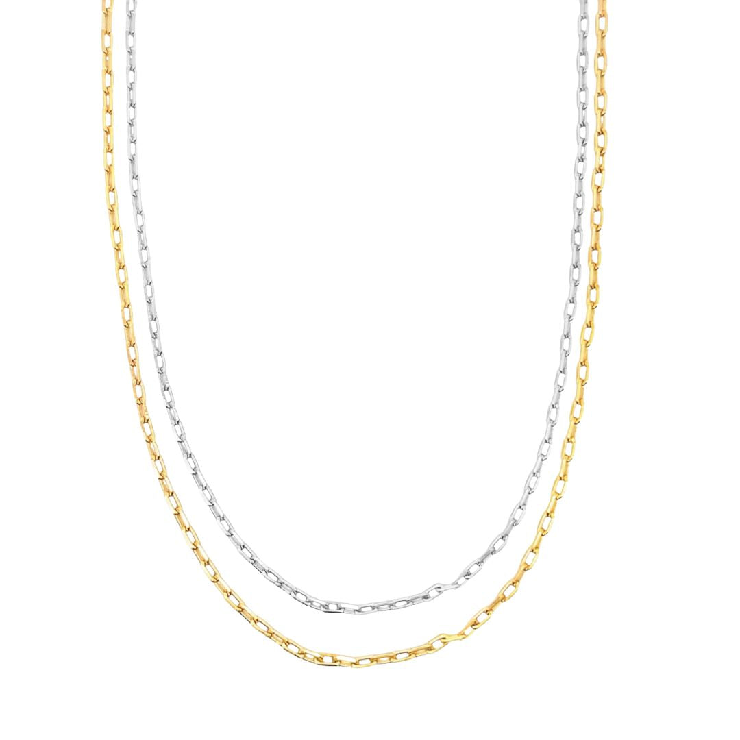 Two layered paperclip link necklaces in silver and gold rest on a white background.