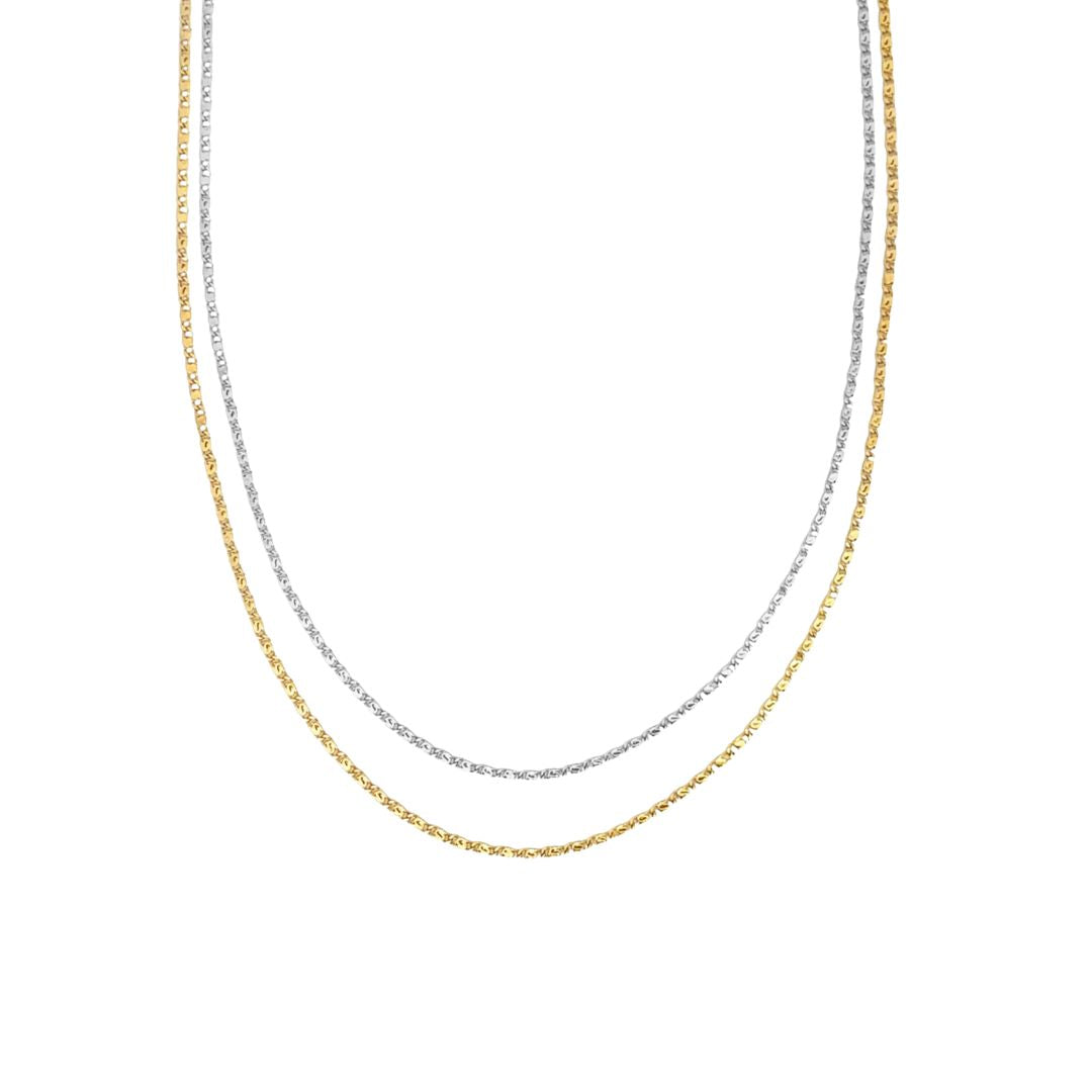 Two delicate layered chains, one in gold and one in silver, rest against a white background.
