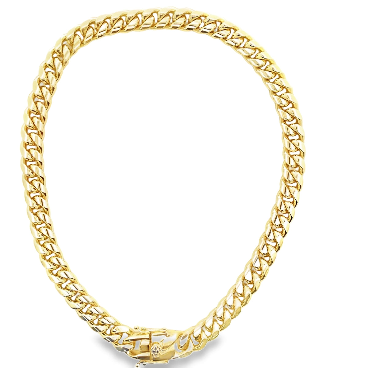 A thick gold Cuban link chain lies in a circle against a white background.