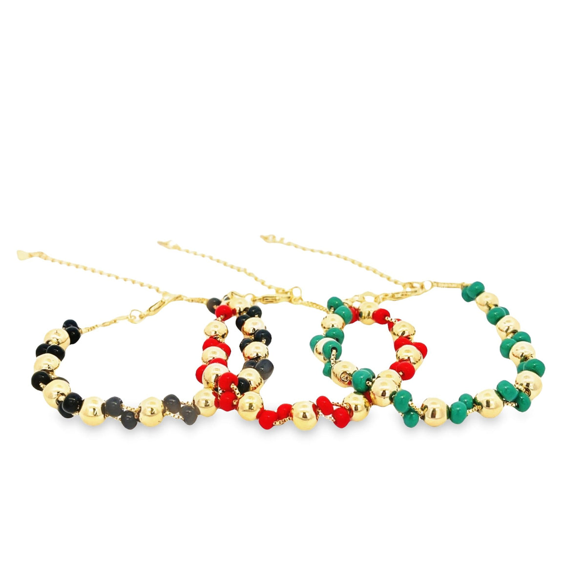 Three beaded gold chain bracelets feature alternating black and grey, red and gold, and green and gold beads against a clean white background.