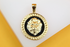 A round gold lion pendant features a detailed lion head against a black enamel center and a Greek key border.