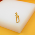 A shiny gold hacksaw pendant rests on a white display block.