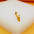 A shiny gold saw pendant rests on a clean white display block.