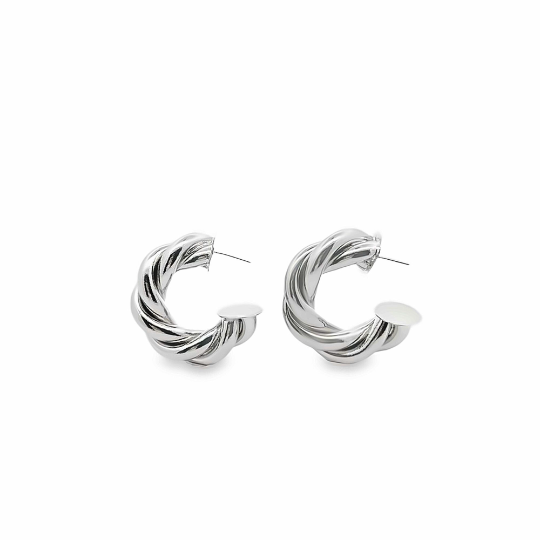 A pair of polished silver twisted hoop earrings rests against a clean white background.