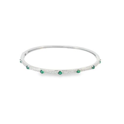 A silver diamond bangle features sparkling pave-set stones accented by evenly spaced vibrant green emeralds.