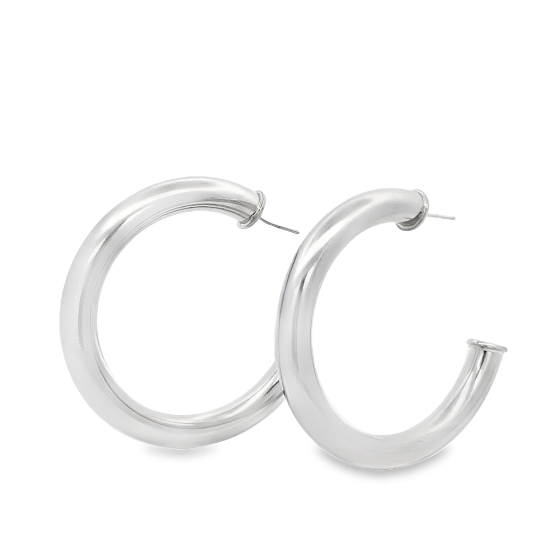 A pair of thick, polished silver hoop earrings rest against a plain white background.