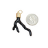 A glossy black branch-shaped pendant with a gold cap rests next to a US quarter coin for scale.