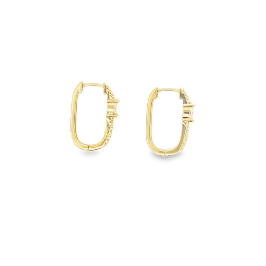 A pair of gold huggie hoop earrings featuring sparkling pave-set diamonds along the outer edge rests against a white background.