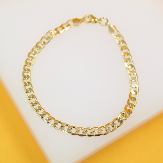 A shiny gold curb chain bracelet rests on a white display against a vibrant yellow background.