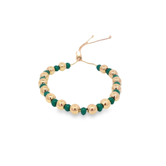 A handmade beaded bracelet features alternating gold spheres and vibrant green beads on an adjustable beige cord against a white background.