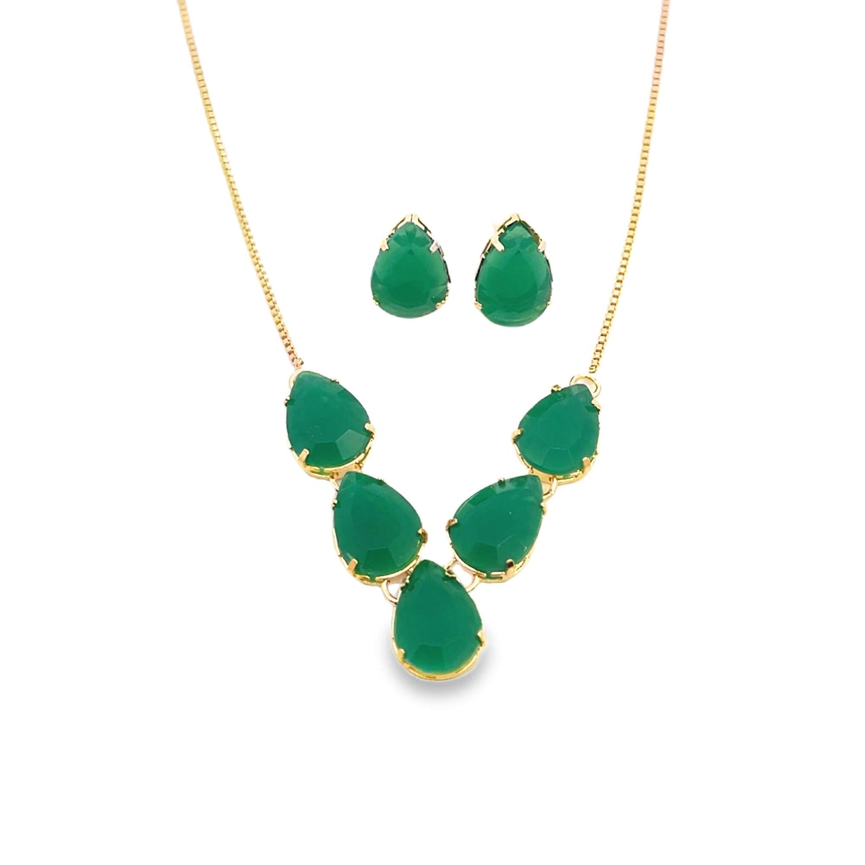 A matching gold jewelry set features a delicate chain necklace and teardrop earrings adorned with vibrant green gemstones against a plain white background.