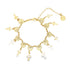 A gold charm bracelet features hanging Saint Benedict medals and cross charms arranged along a delicate chain.