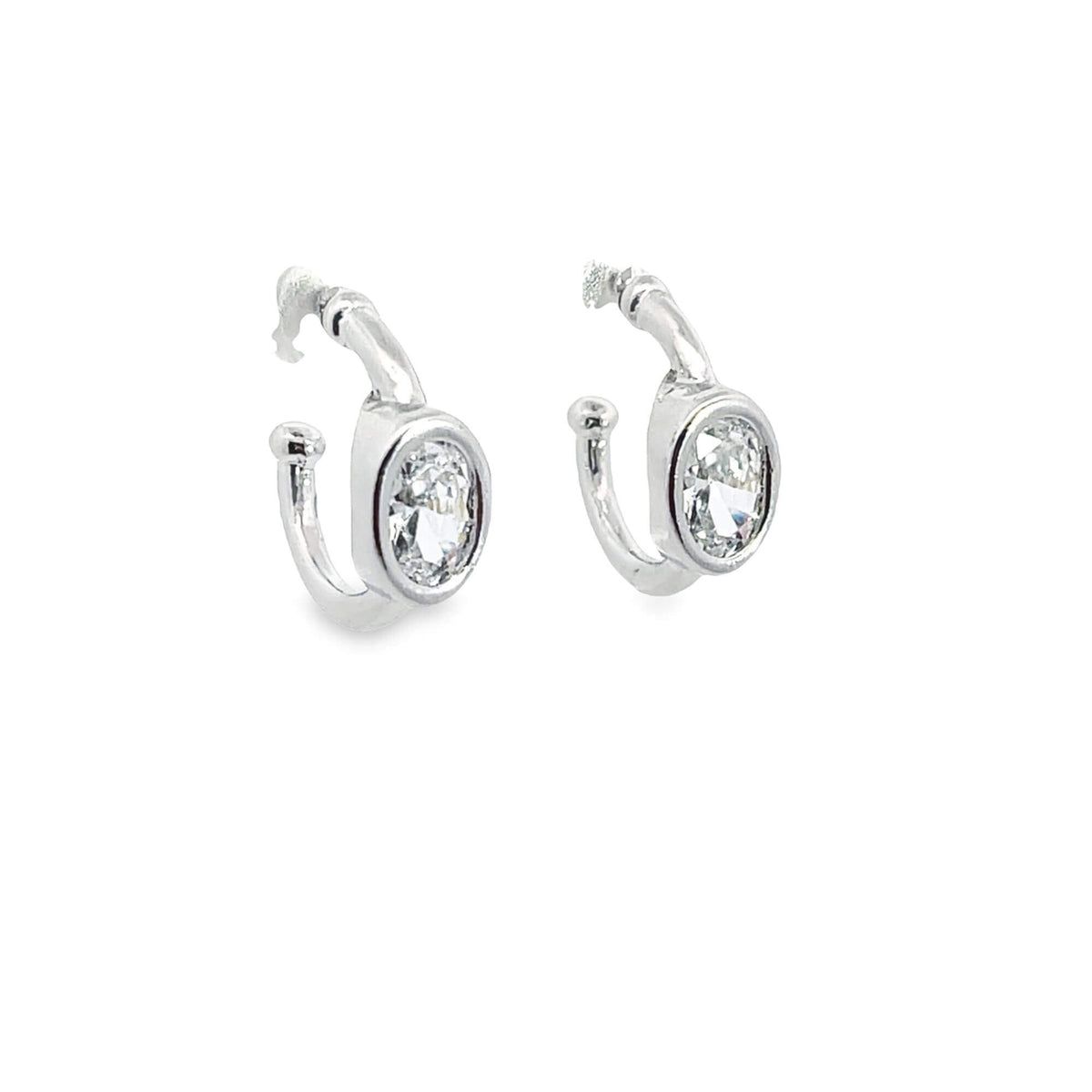 A pair of elegant silver hoop earrings sparkle with bezel-set oval cut diamonds against a clean white background.