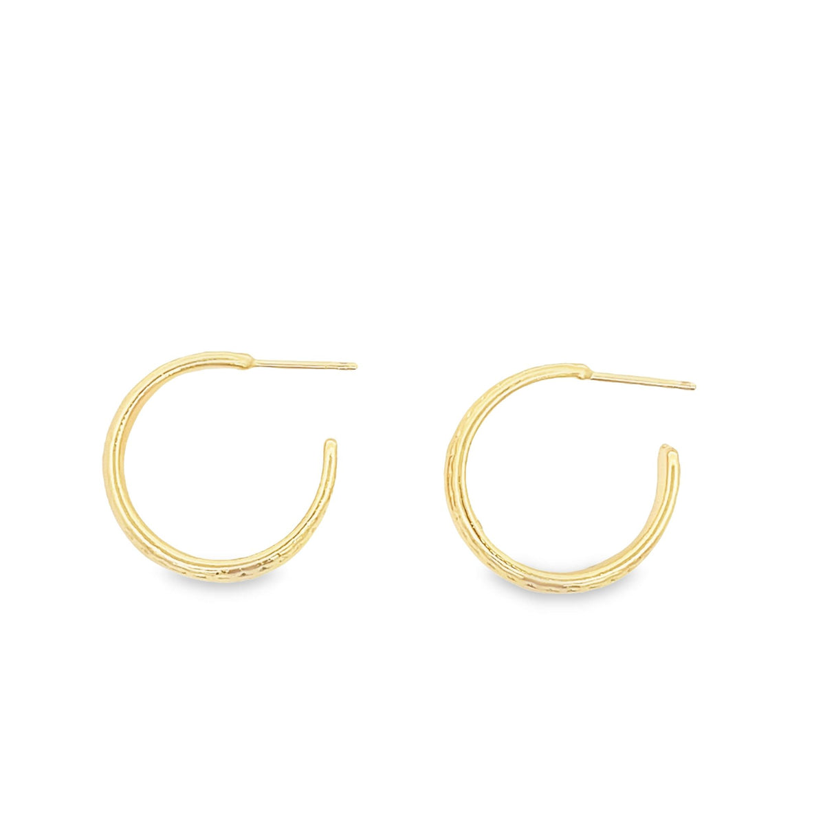 A pair of textured gold hoop earrings rests against a clean white background.