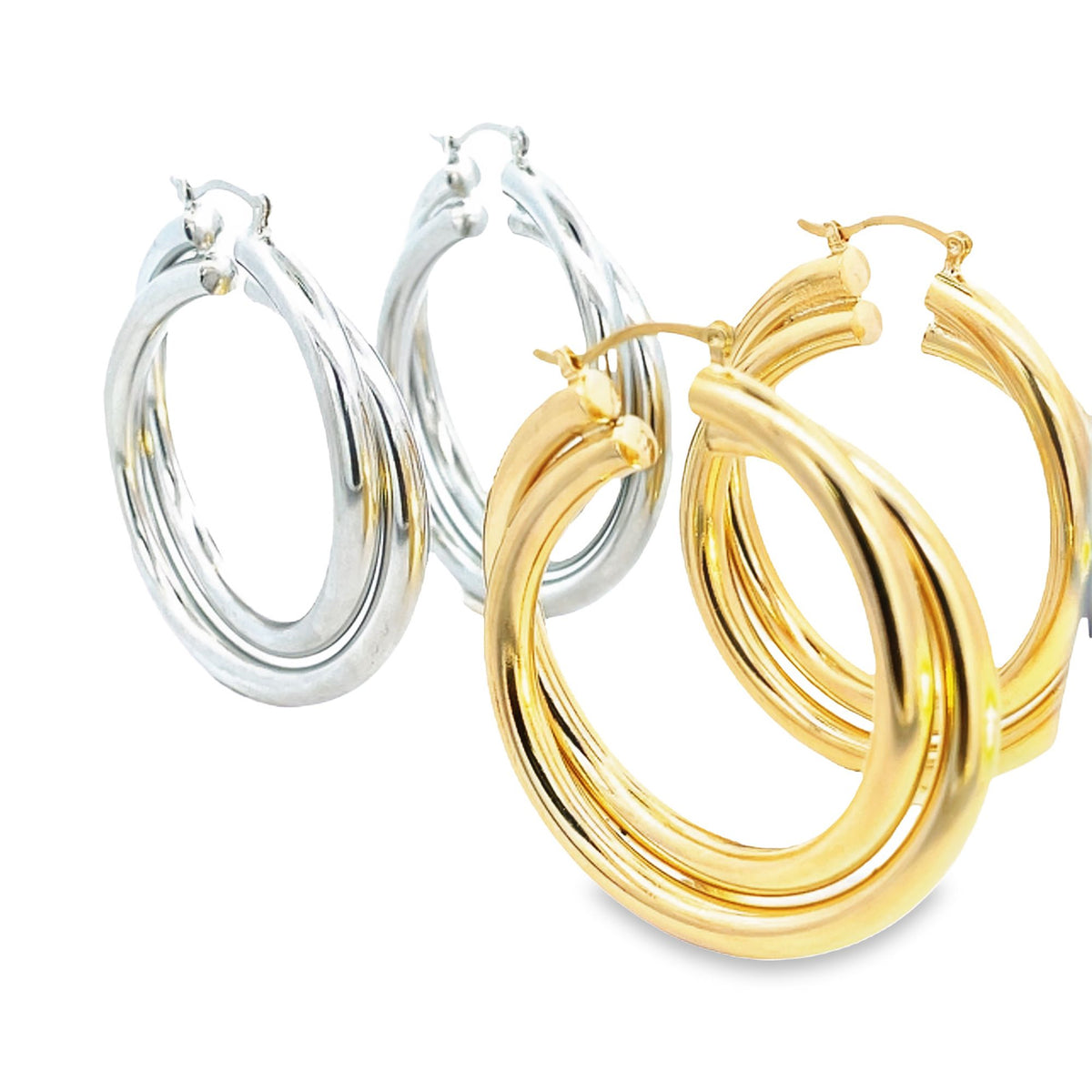 Two pairs of shiny triple-hoop earrings, one in polished silver and the other in vibrant gold, rest against a clean white background.