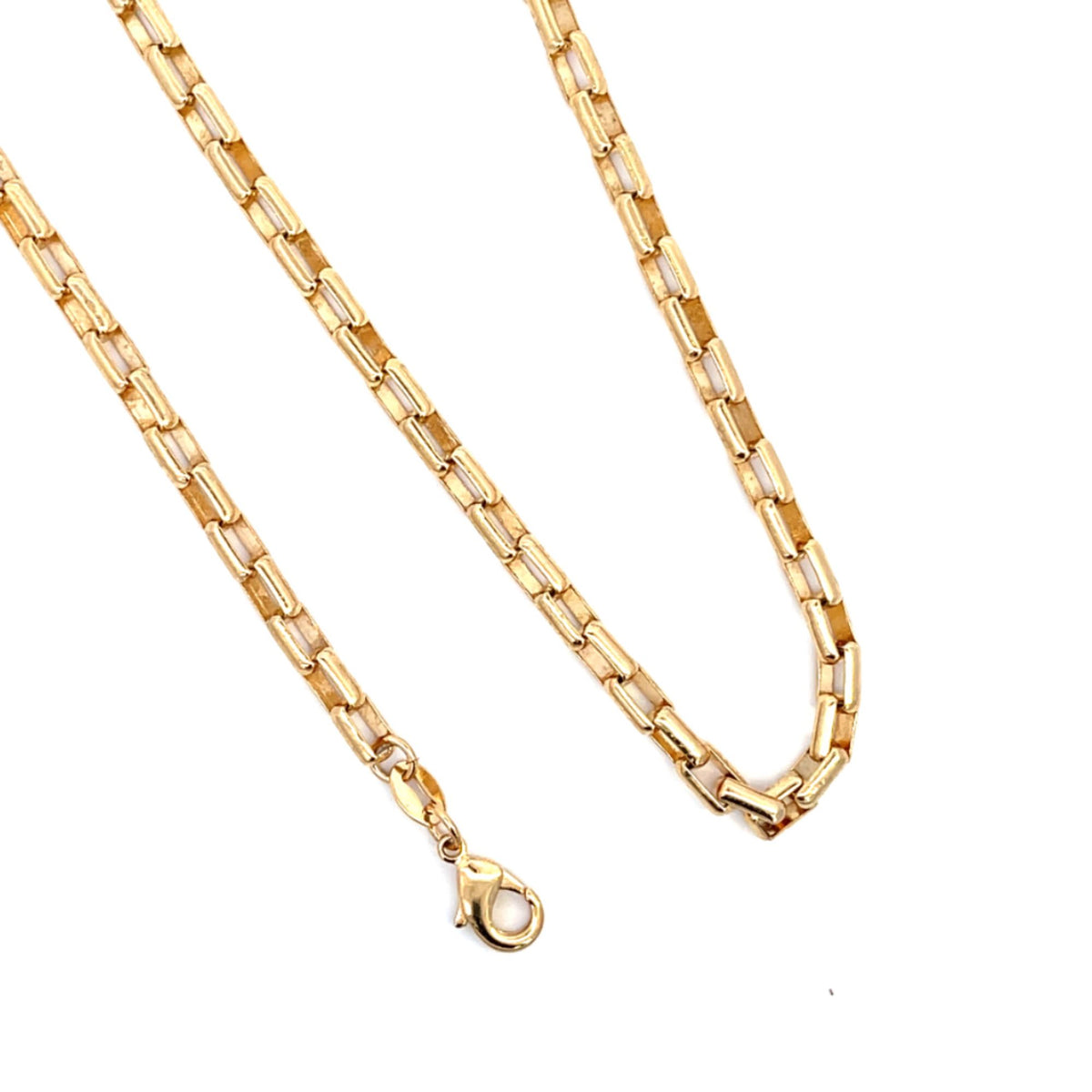A polished yellow gold link chain necklace lies draped against a white background.