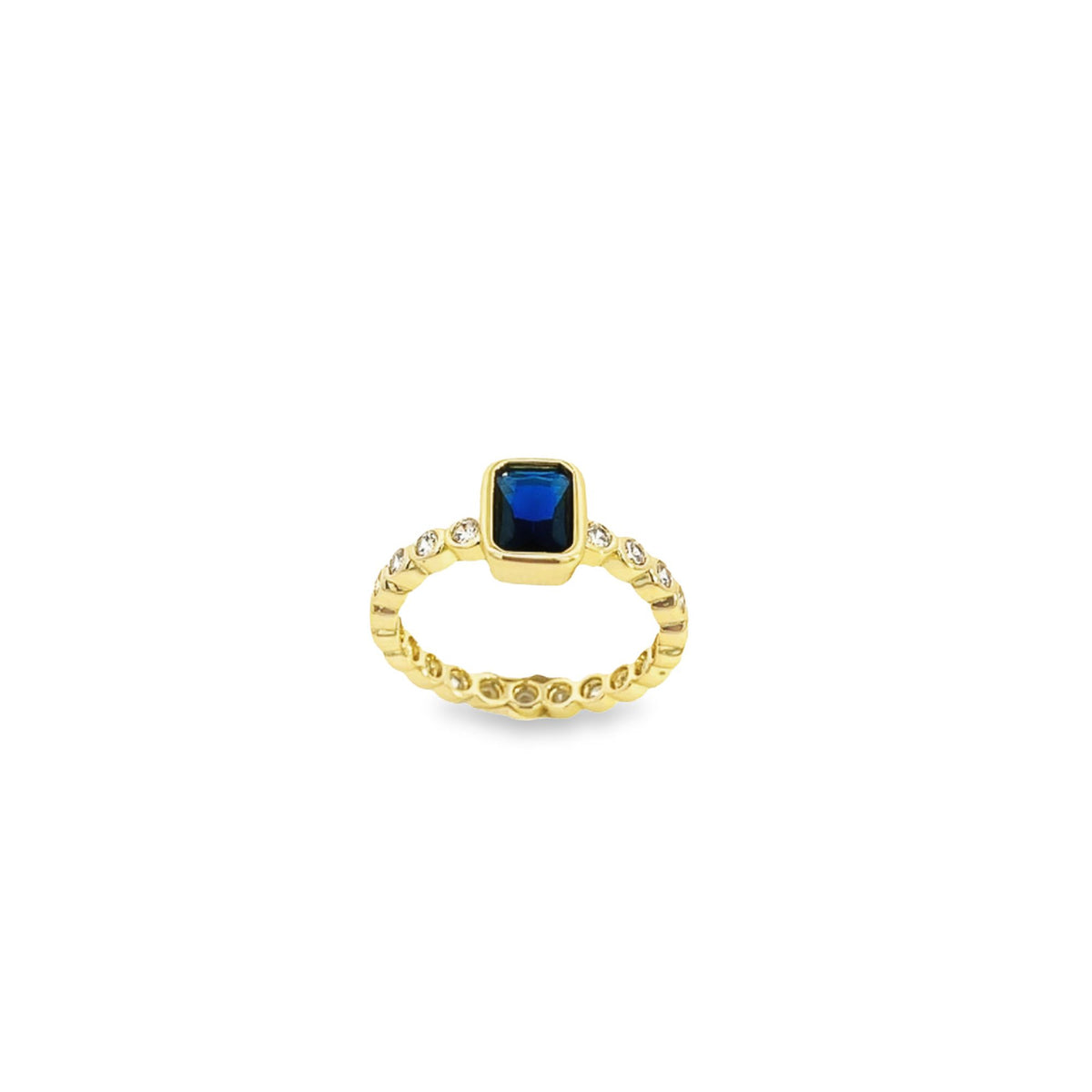 A gold ring features a radiant emerald-cut blue sapphire center stone accented by sparkling diamonds along the band.
