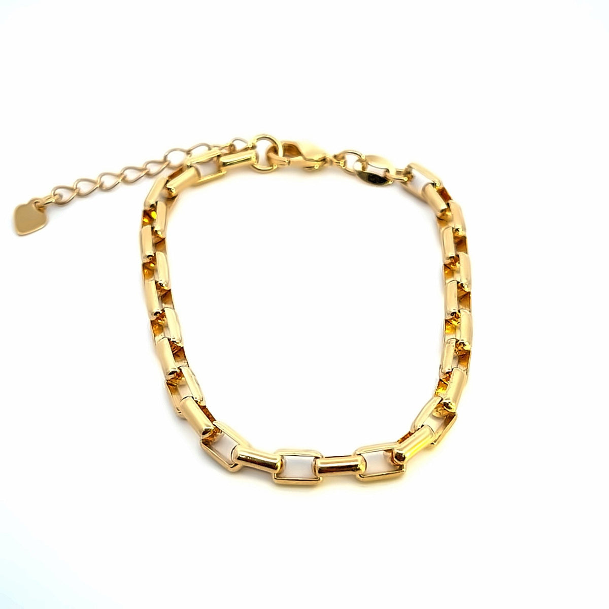 A gold link chain bracelet rests against a clean white background, showcasing its polished geometric segments and delicate extension chain with a tiny heart charm.